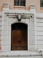 a vintage brown wooden door at a grey building photo