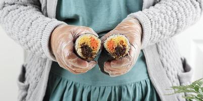 hembra asiático mujer haciendo gimbap, coreano arroz rodar foto