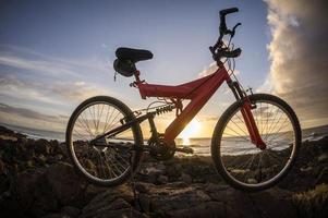 un hermosa puesta de sol ver y un bicicleta foto