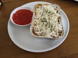 Cedar Cheese and mozzarella on the roasted beef lasagna with chili sauce. The photo is suitable to use for food background, poster and food content media.