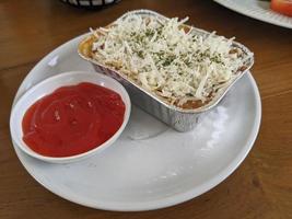 Cedar Cheese and mozzarella on the roasted beef lasagna with chili sauce. The photo is suitable to use for food background, poster and food content media.