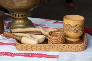 Wooden ethnic spoon and cup on a tray of vines photo