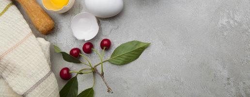 Ingredients baking flour eggs rolling pin berries kitchen textiles on gray background. Cookie pie or cake recipe mockup. Baner preparation for culinary baking. photo