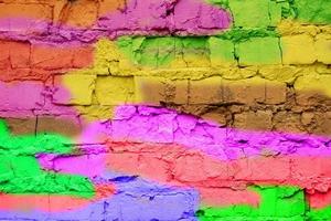 Multi-colored brick wall close-up. Bright fun background in the style of graffiti. photo