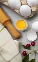 Ingredients baking flour eggs rolling pin berries kitchen textiles on gray background. Cookie pie or cake recipe mockup. Preparing for culinary baking. photo