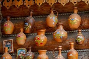 Russia, Moscow, July 28, 2018. Izmaylovsky Park. Clay jugs hang on a wooden wall. photo