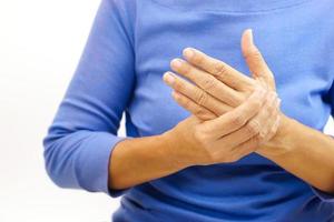 Hand of a woman suffering from hand pain on white background. Healthcare and office syndrome concept. photo