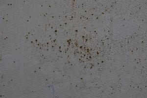 background of old gray wall with cracked plaster in close-up photo