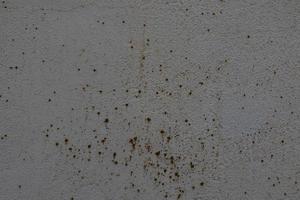 background of old gray wall with cracked plaster in close-up photo