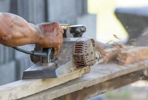 Carpenter working with electric planer photo