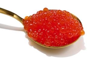 Red sturgeon caviar in a metal spoon on a white isolated background, delicious snack photo