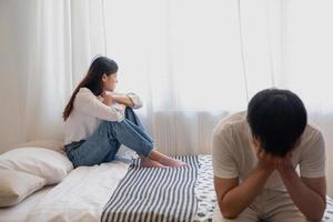 The husband is unhappy and disappointed in the erectile dysfunction during sex while his wife sleeping on the bed. Sexual Problems in Men, The concept of erectile dysfunction according. photo