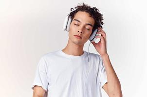 curly-haired guy in white t-shirt with headphones music technology entertainment photo