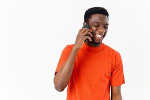 happy guy of african appearance talking on the phone on a light background photo