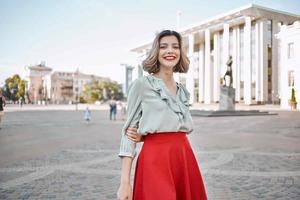 cheerful blonde in a red skirt on the street walk lifestyle photo