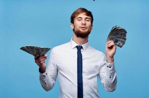 business man in shirt with tie wads of money finance blue background photo