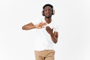 hombre de africano apariencia en auriculares gesticulando con su manos música amante ligero antecedentes foto