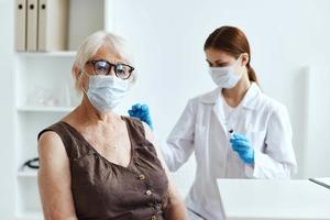 elderly woman wearing a medical mask next to the doctor covid-19 passport photo