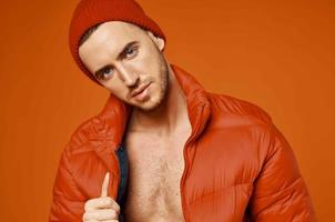 fashionable man in red jacket nude body studio orange background photo
