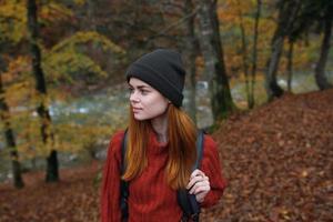 mujer caminante camina en el bosque en otoño en naturaleza cerca el río y hojas paisaje foto