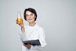 female laboratory assistant in a white coat test tube with a chemical solution analysis photo