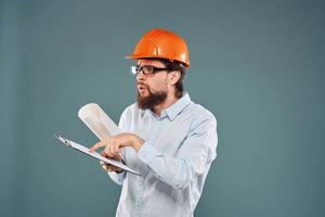 man worker with documents in hands wearing glasses orange helmet safety professional photo