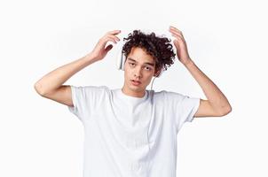 hombre con Rizado pelo escuchando a música con auriculares adolescente Moda nuevo tecnología t camisa foto
