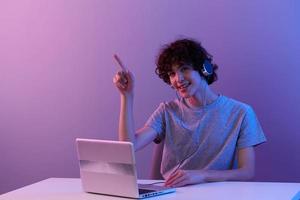 jugador en auriculares en frente de ordenador portátil entretenimiento Violeta antecedentes foto