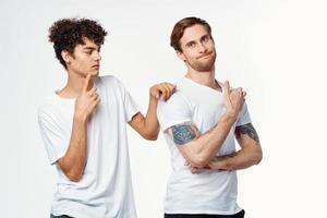 two men in white t-shirts are standing side by side isolated background photo