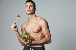 sports guy eating healthy food vegetable salad isolated background photo