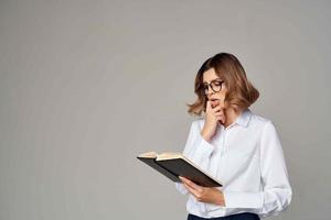 alegre mujer en blanco camisa documentos oficina gerente estudio foto