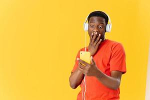 emocional hombre de africano apariencia en auriculares escuchando a música aislado antecedentes foto