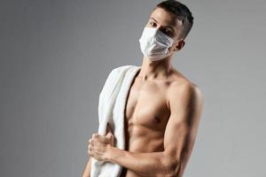 male athletic physique towel on shoulders medical mask photo