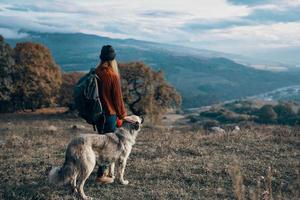 woman hiker nature mountains travel next to the dog freedom friendship photo