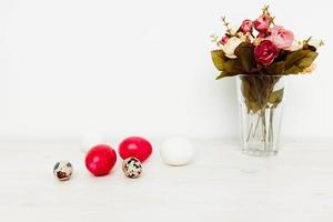 ramo de flores de flores y brillante Pascua de Resurrección huevos en el mesa foto