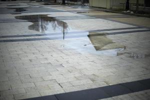 Rain outside. Puddle in square. City in rain. photo