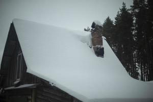 House winter in forest. Lodge in village. Snow on roof. photo