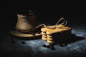 Coffee in a clay cup and cookies on an abstract background photo