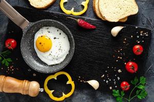 frito huevos en un fritura pan con Fresco vegetales y especias concepto para menú y publicidad. foto