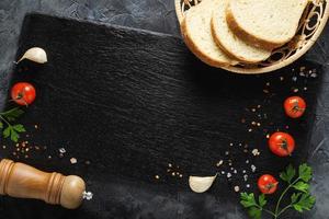 Bread with vegetables on slate board. Copy space. Top view. photo