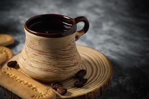 Coffee in a clay cup and cookies on an abstract background photo