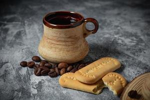 Coffee in a clay cup and cookies on an abstract background photo