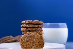 delicioso desayuno de harina de avena galletas con Leche en un azul antecedentes en un suave Mañana foto