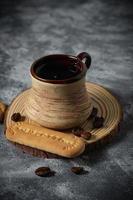 Coffee in a clay cup and cookies on an abstract background photo