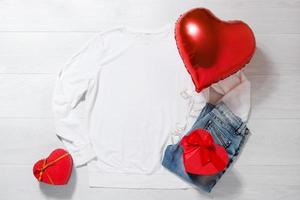 White sweatshirt mockup. Valentines Day concept shirt, balloons heart shape on wooden background. Copy space, template blank front view clothes. Romantic outfit. Flat lay holiday birthday fashion photo