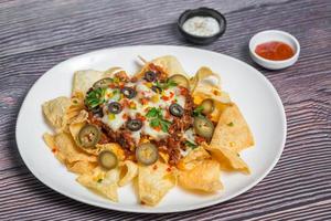 Mexican Famous Food Spicy Ground Beef Nachos. Heated crunchy tortilla chips with melted cheese and jalapeno served a snack food. photo