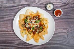 Mexican Famous Food Spicy Ground Beef Nachos. Heated crunchy tortilla chips with melted cheese and jalapeno served a snack food. photo