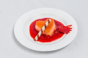 Heart shaped pudding with strawberry sauce and wafer. Valentines dessert recipe. photo