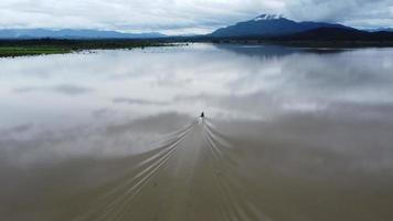 vista aérea de botes de cola larga en el río que fluye después de fuertes lluvias e inundaciones en la temporada de lluvias. concepto de cambio climático. video