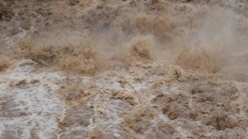 catarata de cascada en las montañas del bosque. arroyos sucios fluyen por las laderas de las montañas del bosque de montaña después de fuertes lluvias en tailandia. inundación del río, enfoque selectivo. video